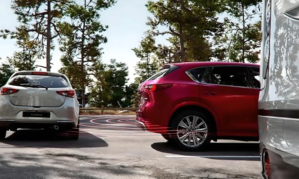 Muestra de&nbsp;tecnologia&nbsp;de seguridad de alerta de&nbsp;trafico&nbsp;cruzado en reversa en un auto Mazda.